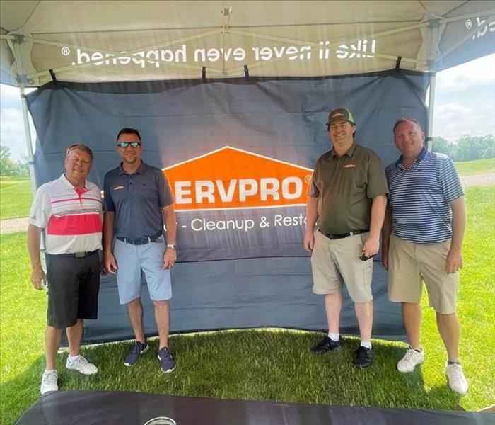 SERVPRO golf team standing in front of tent