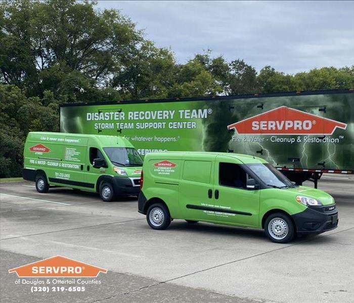 Two SERVPRO vans in front of a SERVPRO trailer. 